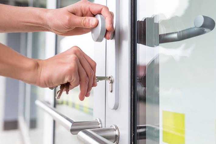Unlocking the cylinder lock on a glass commercial storefront door